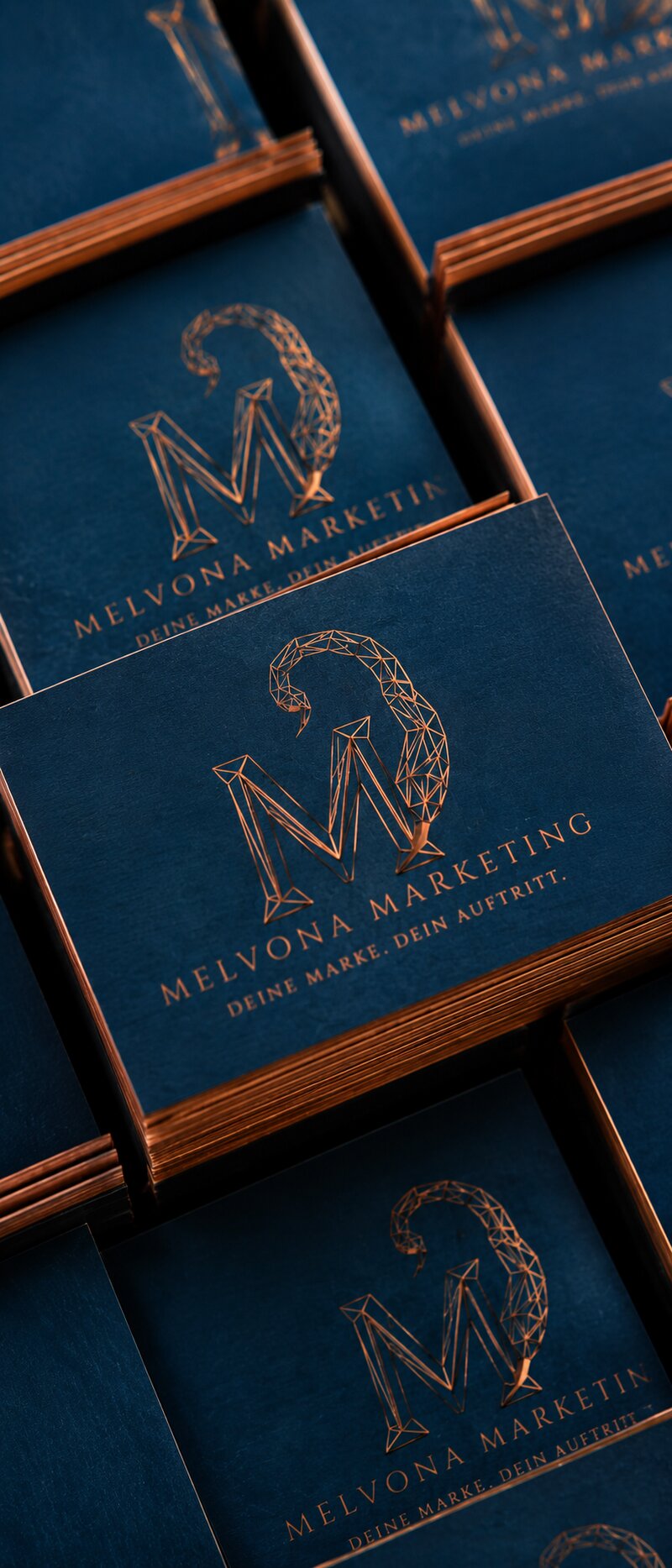 Gestapelte Visitenkarten von Melvona Marketing in Navy und Kupfer